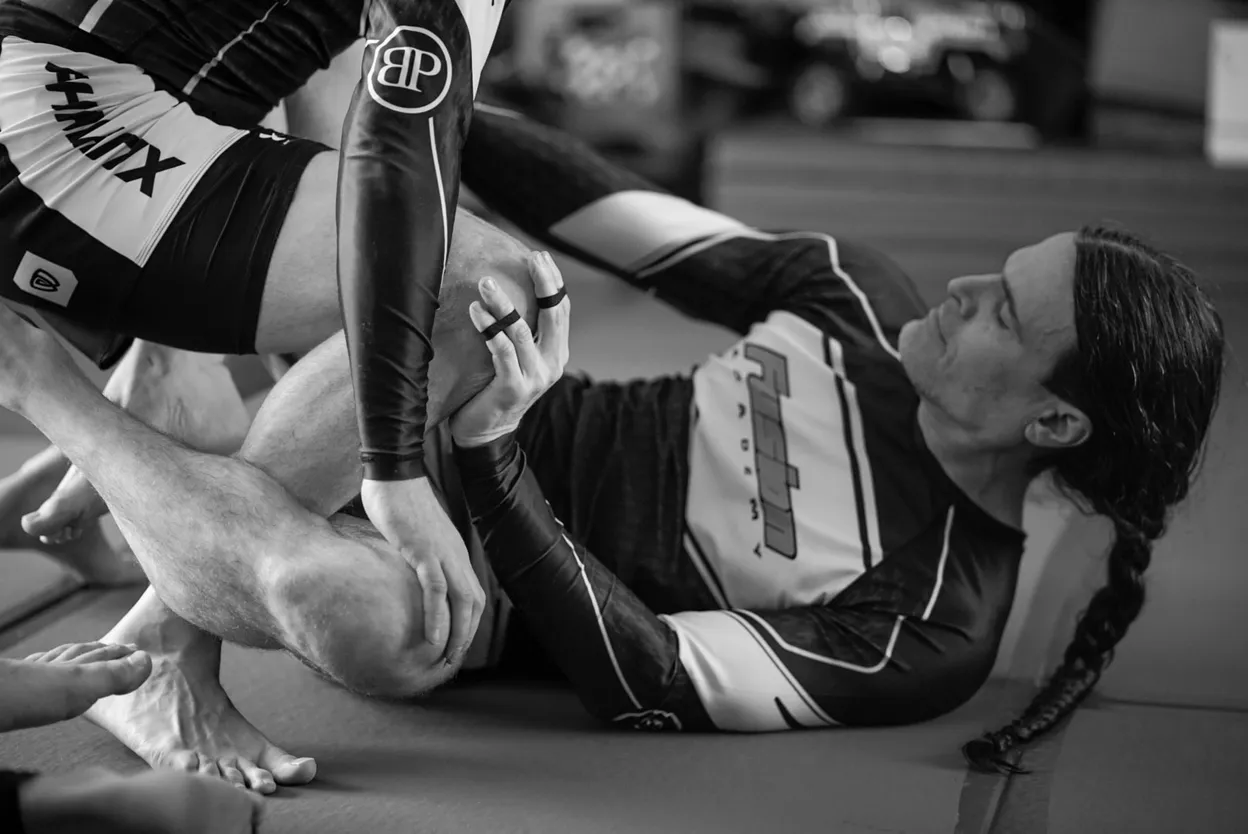 Two training partners practicing No-Gi grappling on the mats