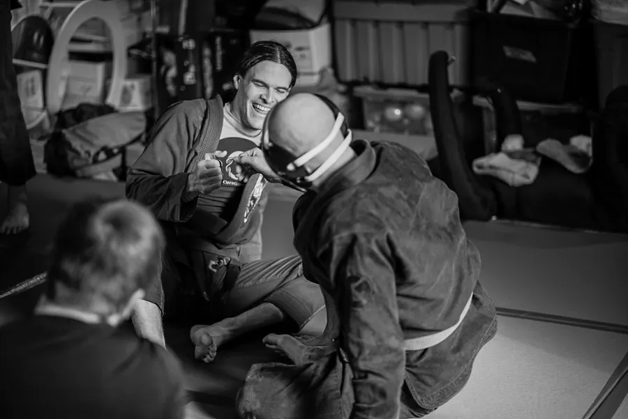 Two Fusion training partners sharing a relaxed moment on the mats