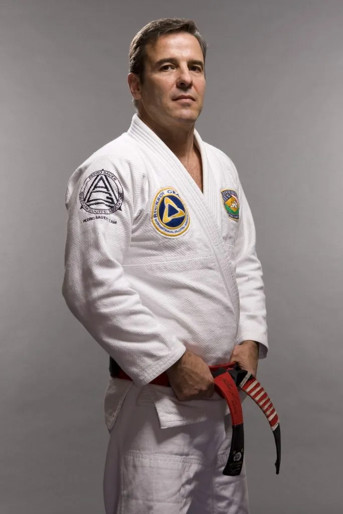 Pedro Sauer wearing a white gi and coral belt